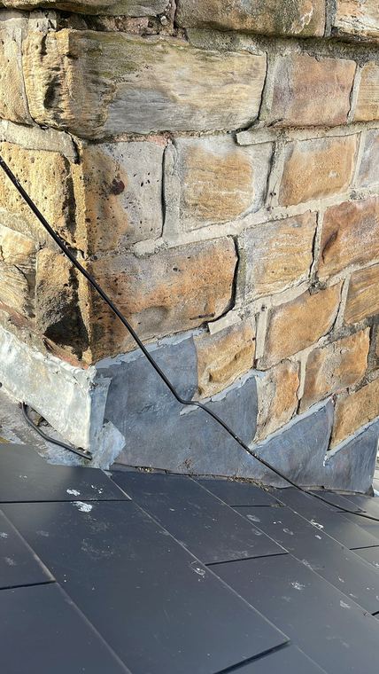 New lead flashing dressed around a stone chimney