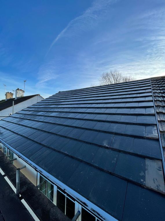 Finished slate-effect roof against a blue sky